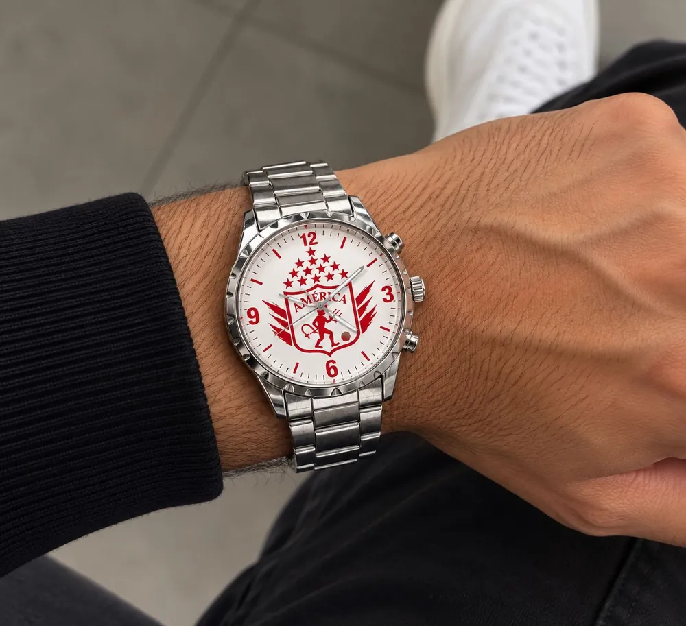 Reloj plateado con escudo de equipo en la carátula, puesto en la muñeca