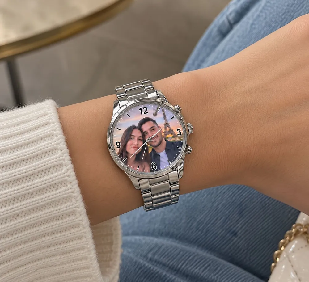 Reloj plateado con foto de pareja en la carátula, puesto en la muñeca